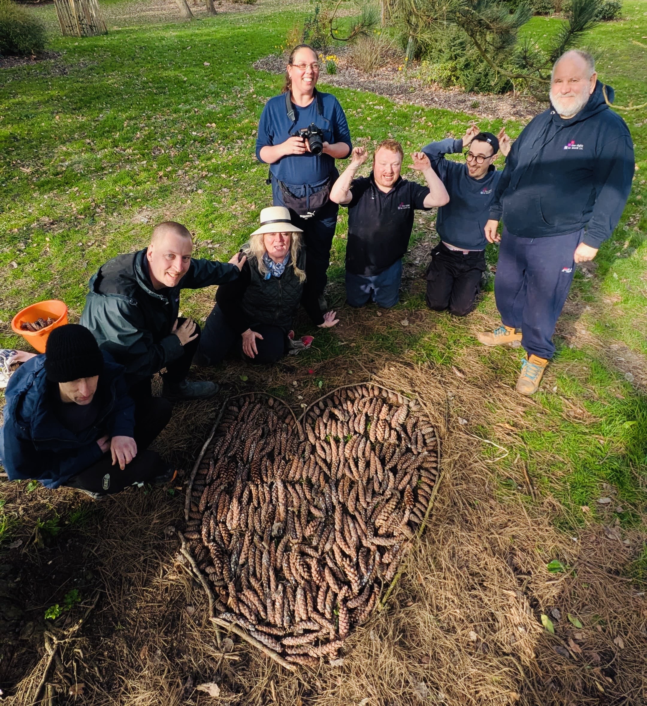The Red Gloves group gathers beside a circular land-art arrangement of sticks at Staunton Country Park.